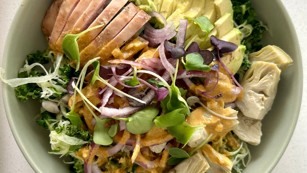 A perfectly balanced salad with chicken, avocado, and artichokes