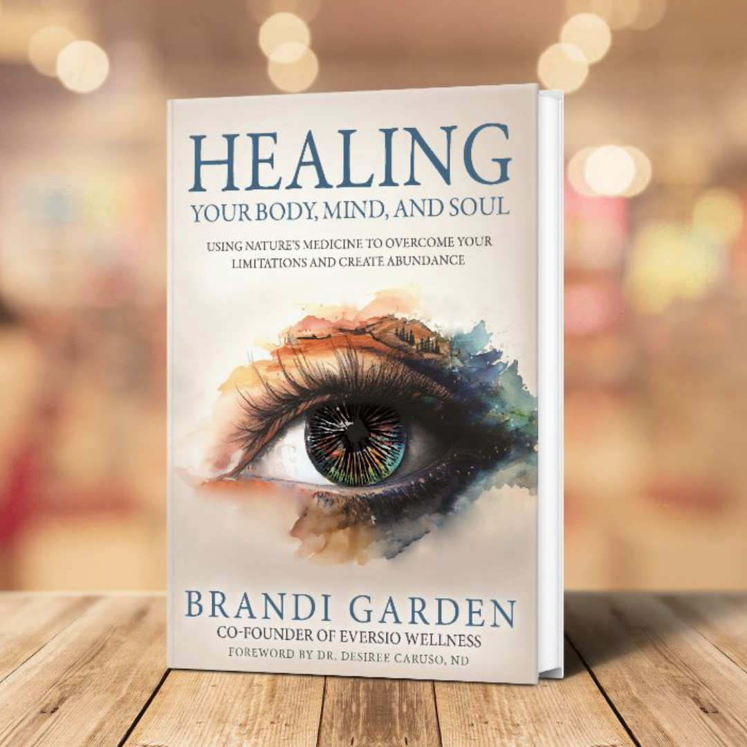 Book titled 'Healing Your Body, Mind, and Soul' by Brandi Garden on a wooden surface with blurred lights in the background.