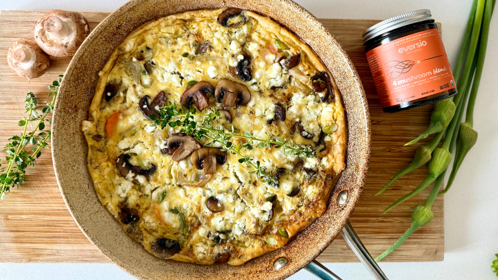 Showcasing the finished frittata in the skillet with bubbling cheese and vibrant veggies